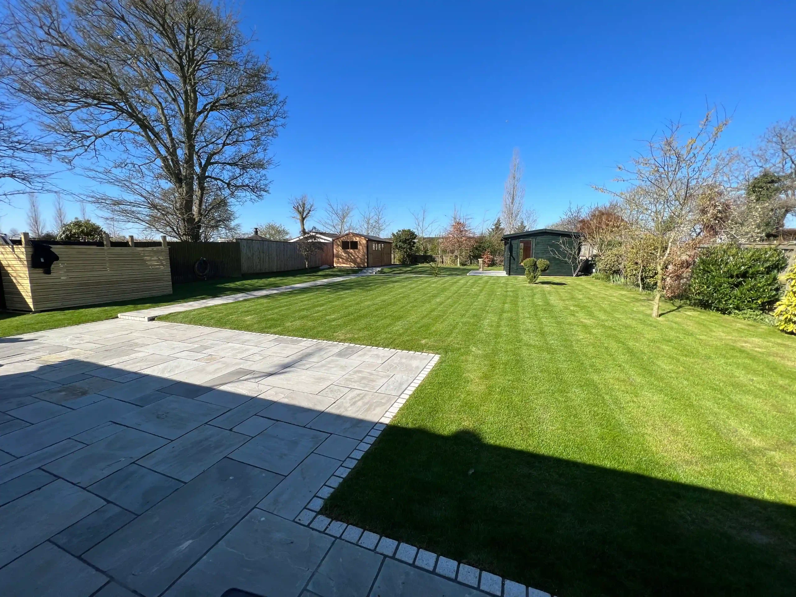 Garden transformation with bespoke wooden sheds and sandstone patio